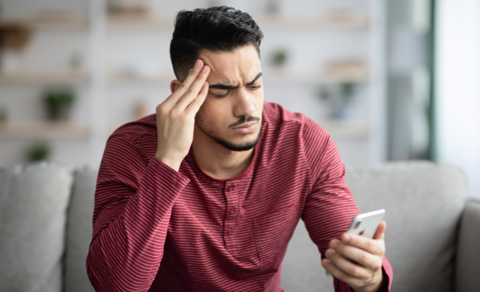 A person looking frustrated wathcing a funeral service stream on their phone 