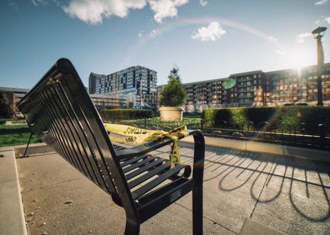 City view of a park bench with office buildings in the background 